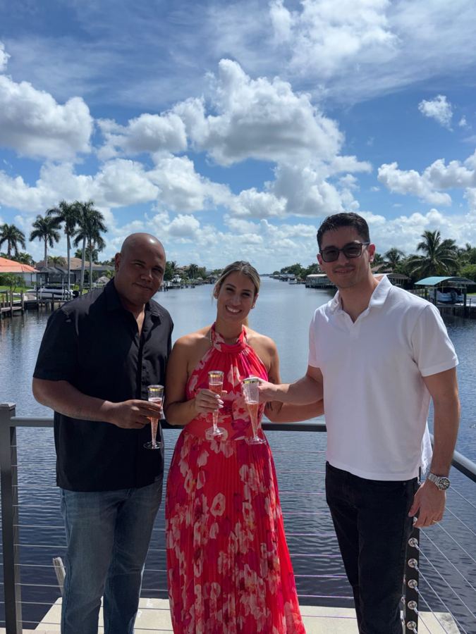 Clients toasting with Marco on their new waterfront balcony