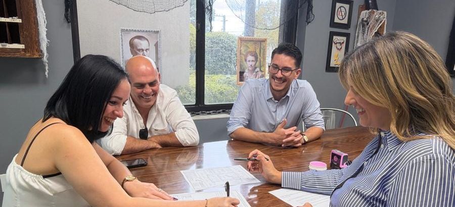 Clients laughing with Marco while signing their closing documents